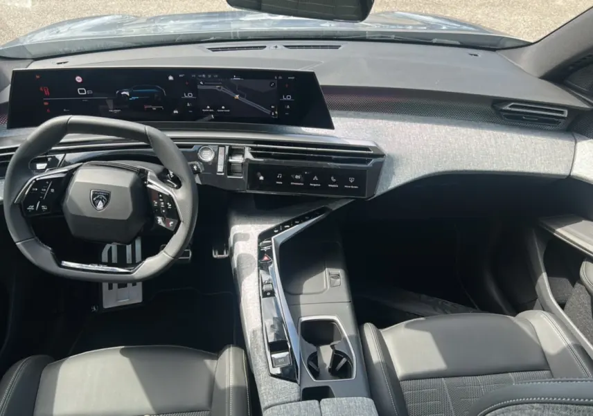 Vue intérieure du poste de conduite du Peugeot 5008 Hybrid 145 GT 7 places 2025, avec tableau de bord numérique et sellerie cuir noire.