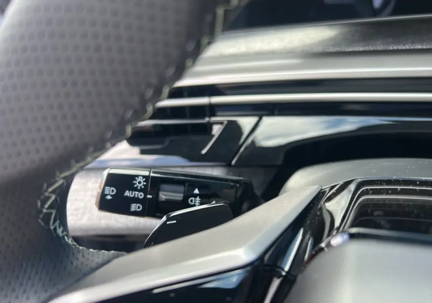 Gros plan sur la commande des feux et clignotants côté gauche du volant du Peugeot 5008 Hybrid 145 GT 7 places gris Artense 2025.