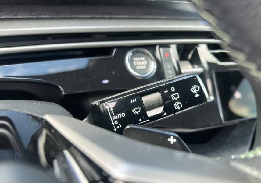 Gros plan sur la commande des essuie-glaces et le bouton start du tableau de bord du Peugeot 5008 Gris Artense 2025.