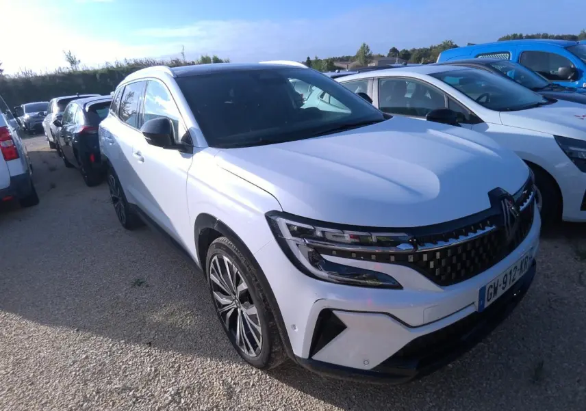 Renault Austral blanc nacré vu en 3/4 avant droit, avec calandre à damier noire et jantes alliage 20 pouces.