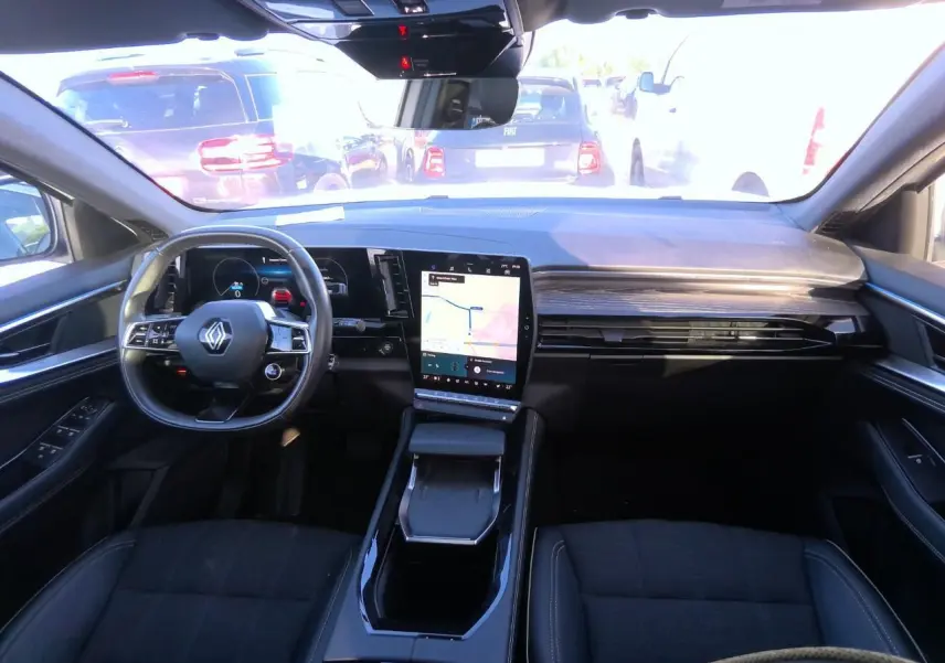 Intérieur noir du Renault Austral 2024, vue de face sur le tableau de bord avec écran tactile central et volant multifonction.