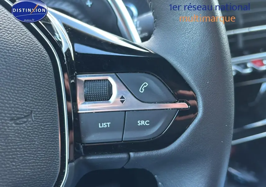 Gros plan sur les commandes du volant noir du Peugeot 2008 1.2 hybrid 145 allure e-dcs6, boutons multifonctions visibles.