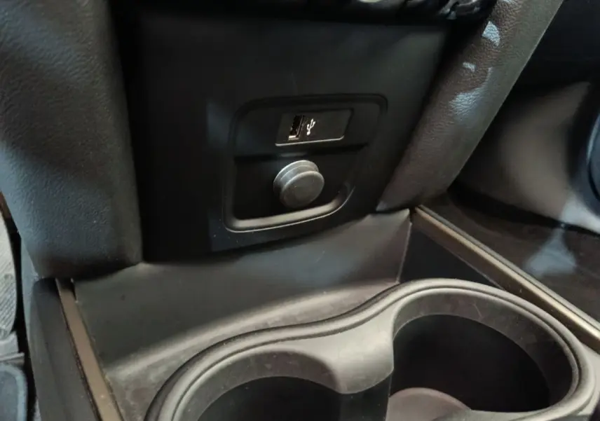 Détail intérieur du MINI Countryman blanc 2021 montrant une prise USB et un port 12V près des porte-gobelets.