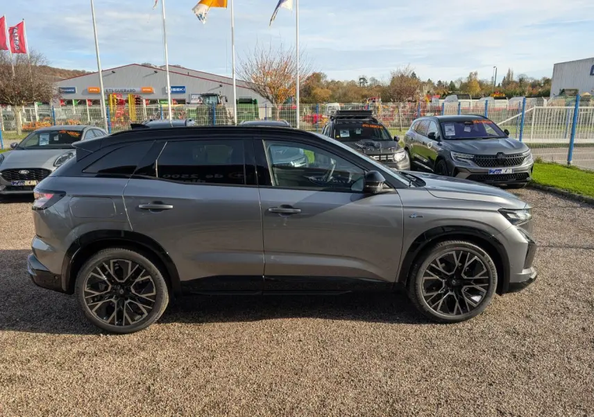 Profil droit du Renault Austral gris métallisé avec toit noir étoilé et jantes alliage 20 pouces diamantées noir.