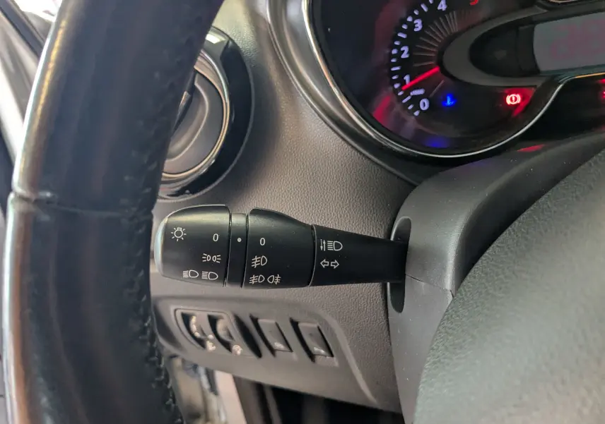 Gros plan sur la manette de commande des phares et clignotants côté gauche du tableau de bord du Renault Captur gris clair 2017.