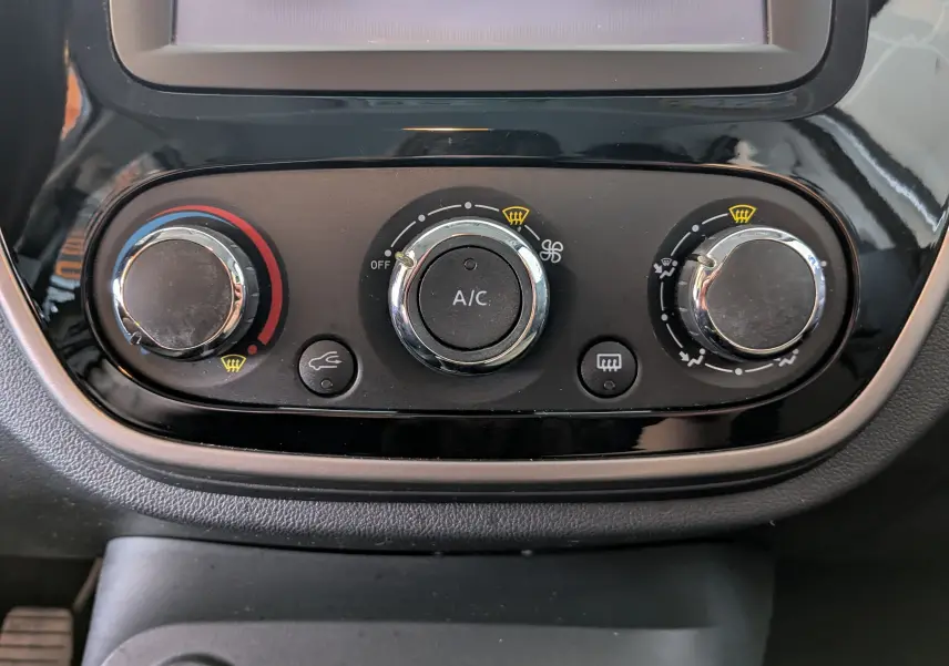 Gros plan sur les commandes de climatisation du tableau de bord du Renault Captur gris clair, version 2017.