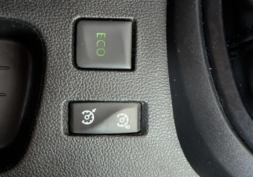 Gros plan sur les boutons de commande ECO et régulateur de vitesse sur la console centrale d’un Renault Captur gris clair 2017.