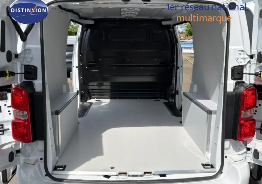 Vue arrière du Citroën Jumpy blanc Kaolin avec portes ouvertes montrant l’espace de chargement vide et aménagé.