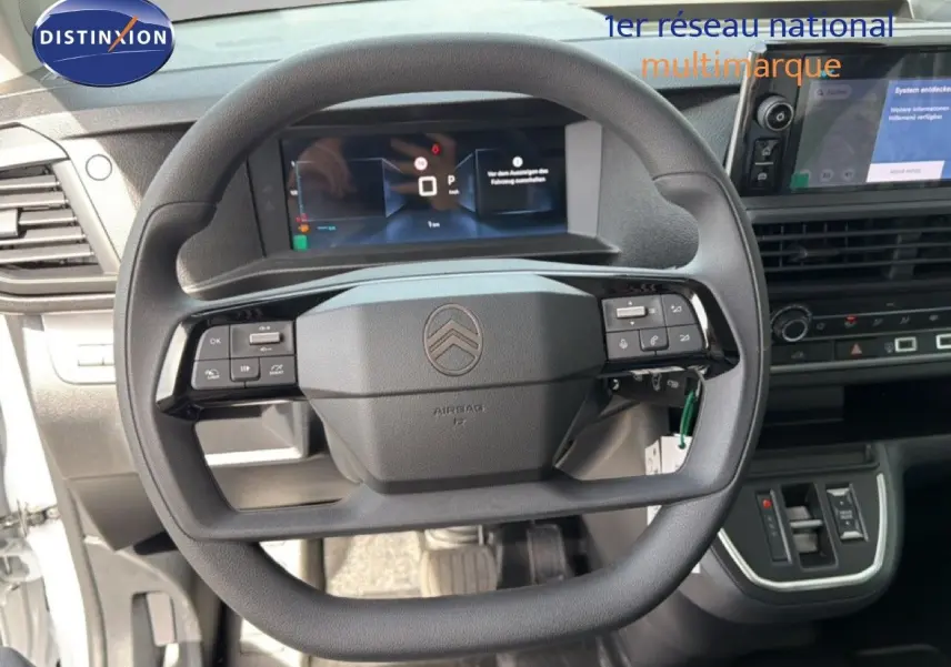 Vue intérieure centrée sur le volant noir de la Citroën Jumpy avec tableau de bord digital et console centrale visible.
