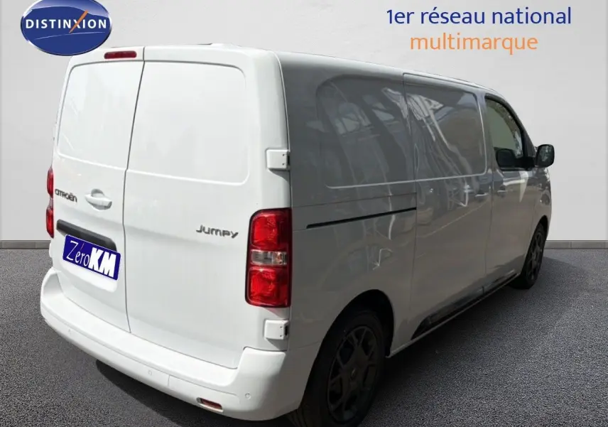 Vue 3/4 arrière droite d'un Citroën Jumpy blanc Kaolin, fourgon utilitaire avec vitres teintées et jantes noires.