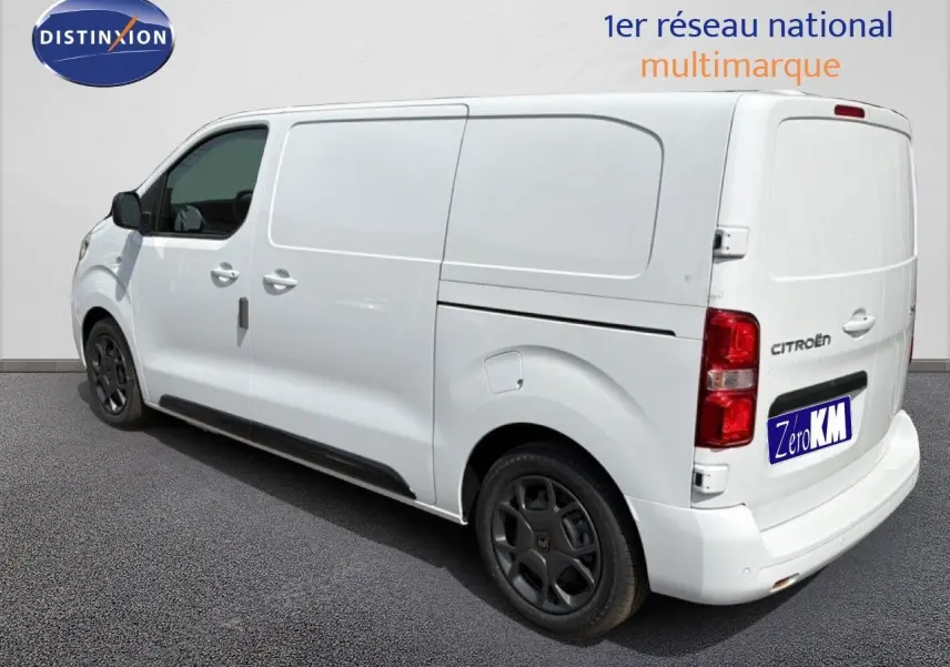 Vue 3/4 arrière droite d’un Citroën Jumpy blanc Kaolin, fourgon utilitaire avec jantes noires et vitres teintées.