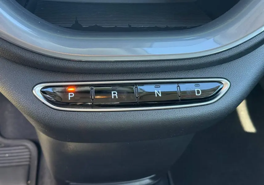 Gros plan sur la commande de boîte automatique avec bouton P allumé dans une Fiat 500 électrique jaune 2024.