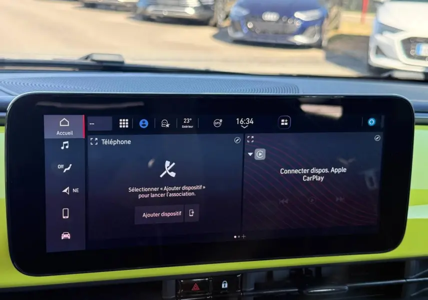 Écran tactile central de la Fiat 500 e jaune, affichant les options téléphone et Apple CarPlay, tableau de bord coloré.
