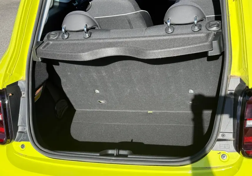 Coffre ouvert vu de l'arrière d'une FIAT 500 électrique jaune Amalfi, banquette arrière rabattable visible.