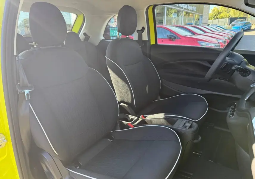 Vue intérieure côté gauche montrant les sièges noirs avec surpiqûres blanches d'une FIAT 500 électrique jaune 2024.