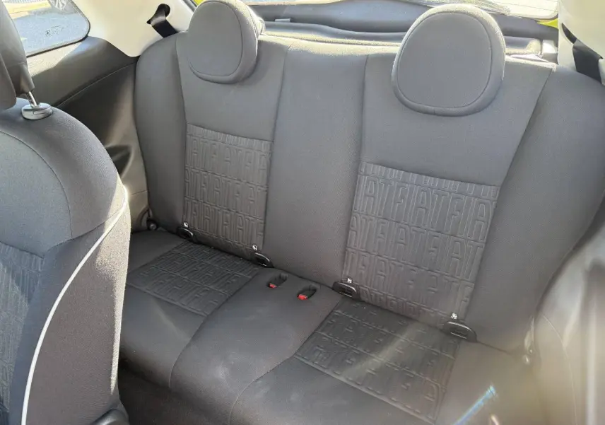 Vue intérieure de la banquette arrière noire avec motifs Fiat, dans une Fiat 500 e jaune 2024.
