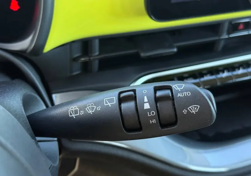 Gros plan sur la commande des essuie-glaces dans l’habitacle jaune vif de la Fiat 500 électrique MY24.
