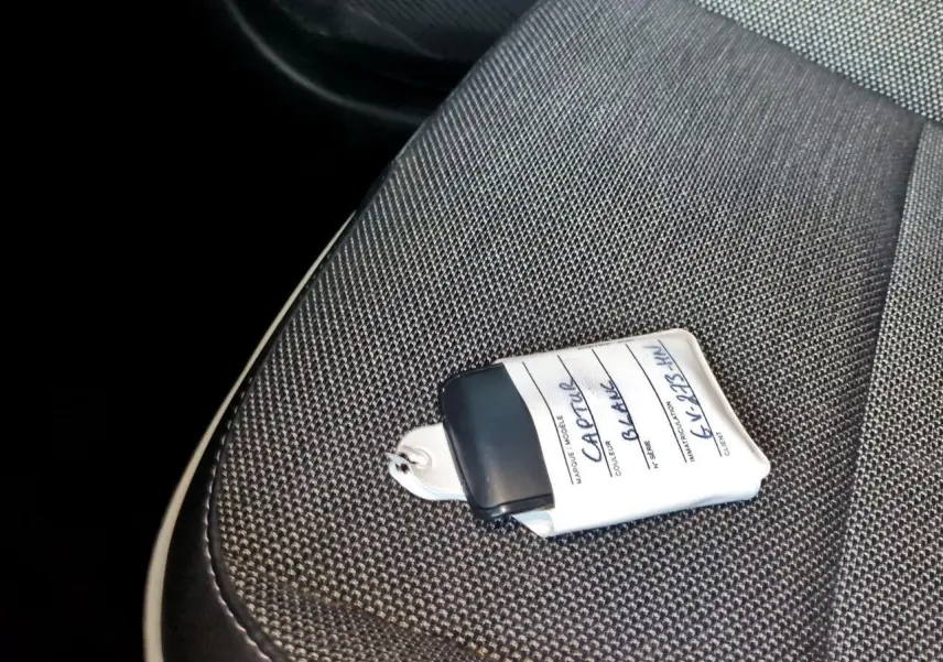 Gros plan sur la clé blanche posée sur le siège tissu gris foncé de la Renault Captur 2024.