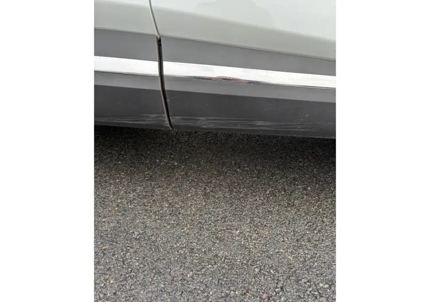 Gros plan sur la partie basse côté droit d’un Renault Captur blanc avec rayures visibles sur le bas de caisse.