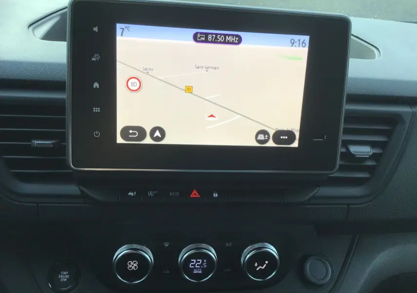 Vue rapprochée du tableau de bord du Renault Trafic Fourgon 2025, écran tactile avec navigation et commandes climatisation.