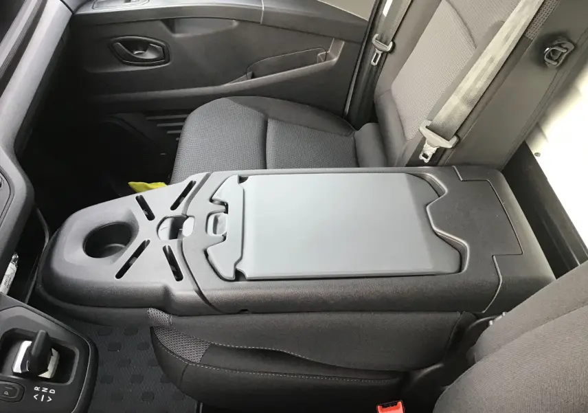 Vue intérieure côté passager du Renault Trafic Fourgon blanc 2025, banquette avec bureau mobile intégré.