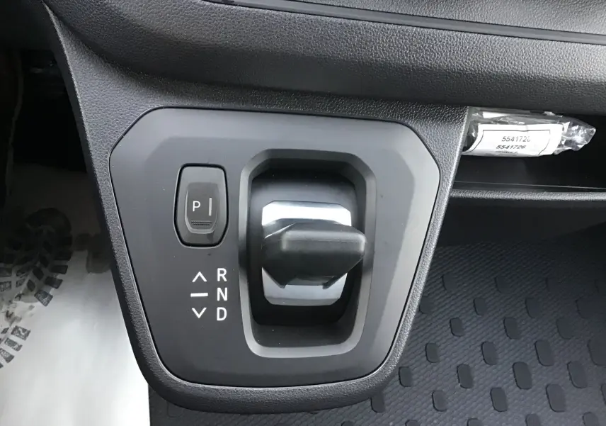 Gros plan sur le levier de vitesses automatique noir du Renault Trafic Fourgon blanc, avec bouton parking et indications R, N, D visibles.