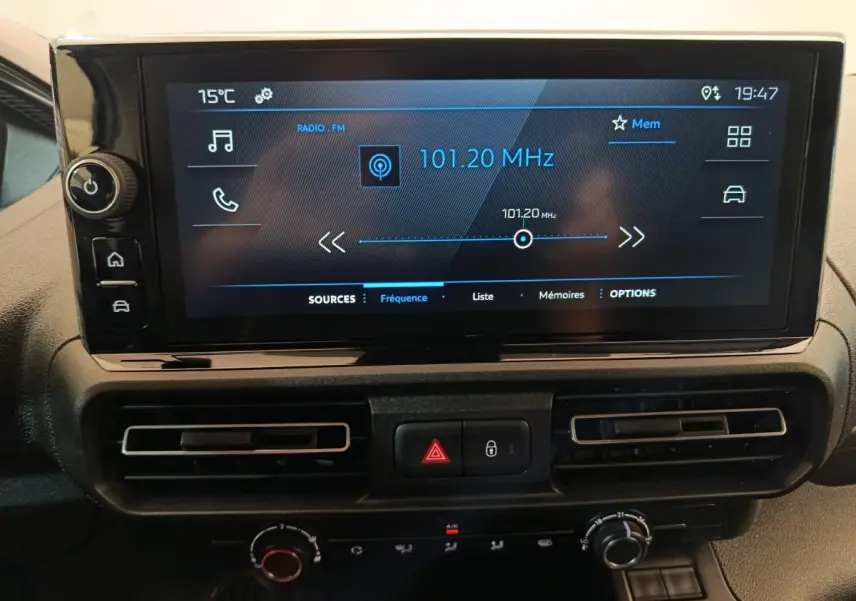 Écran tactile central du tableau de bord du Peugeot Partner blanc 2025, affichant la radio FM à 101,20 MHz.