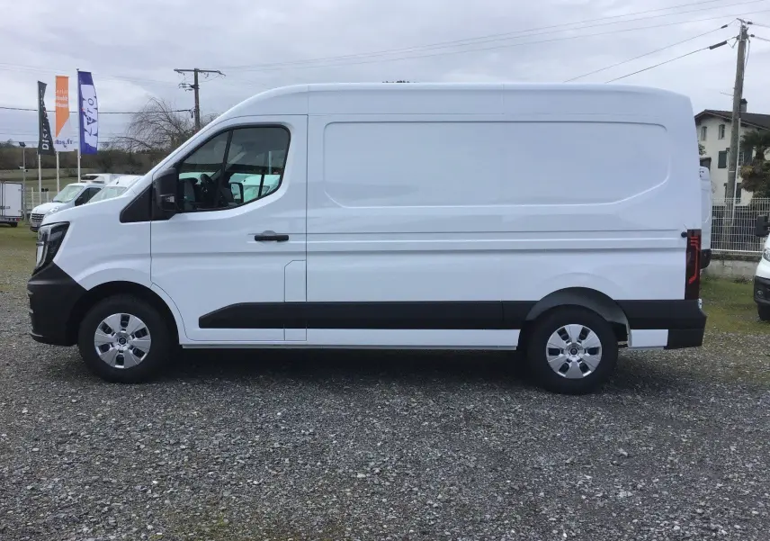Vue latérale gauche d’un Renault Master blanc L2H2, fourgon utilitaire avec protections noires sur les bas de caisse.