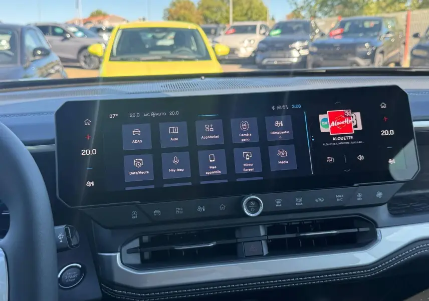 Vue intérieure du tableau de bord du Jeep Compass 2026 avec écran tactile large et commandes climatisation intégrées.
