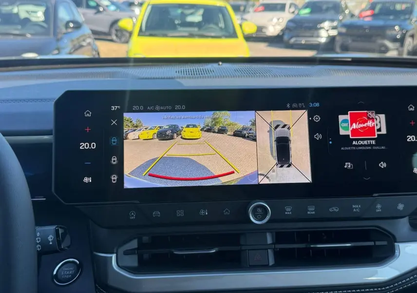 Vue intérieure du tableau de bord du Jeep Compass 2026 avec écran tactile affichant la caméra de recul et l'interface multimédia.
