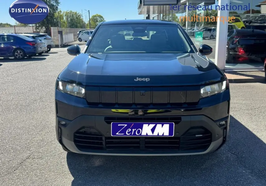 Vue avant d'un Jeep Compass 2026 couleur Vulcano avec calandre noire et phares LED fins, stationné en extérieur.