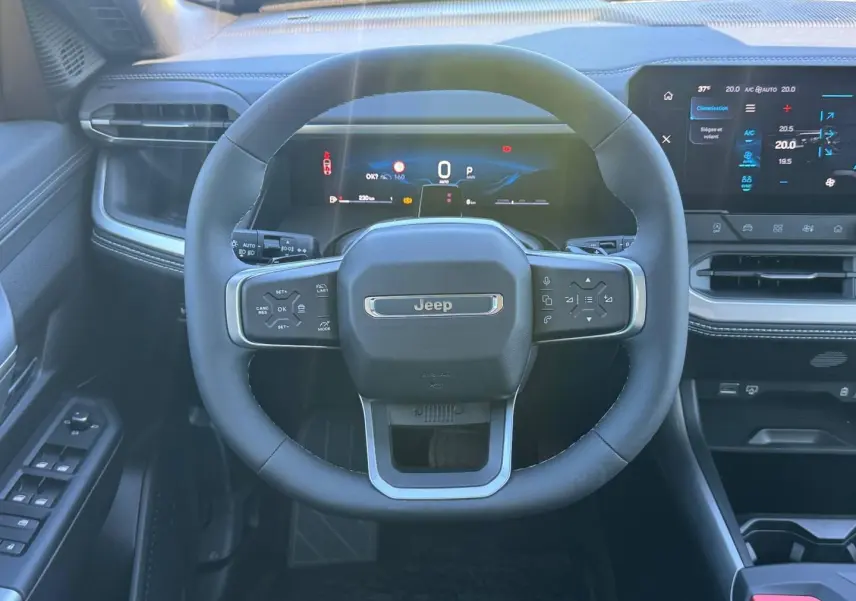 Vue frontale du volant Jeep Compass 2026 avec tableau de bord numérique et écran tactile, intérieur noir et gris anthracite.