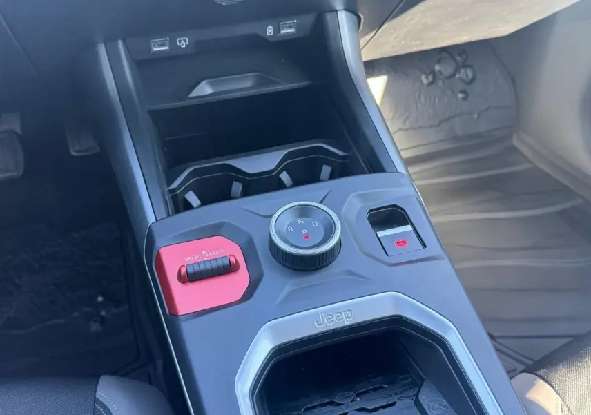 Vue rapprochée de la console centrale du Jeep Compass 2026, avec molette de boîte auto et bouton rouge Selec Terrain.