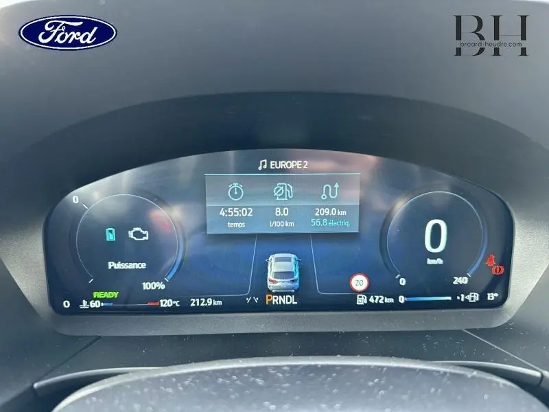 Tableau de bord numérique du Ford Kuga 2025 affichant la consommation, vitesse à 0 km/h et indicateurs hybrides.