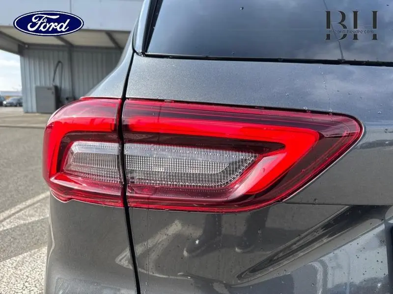 Gros plan sur le feu arrière droit rouge et blanc du Ford Kuga gris Magnetic Fashion Métallisée 2025.