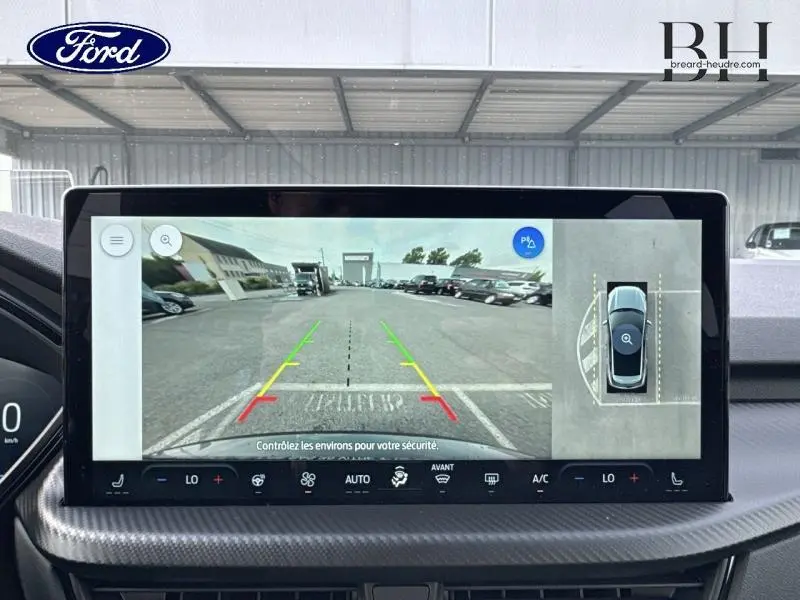 Écran tactile intérieur du Ford Kuga 2025 montrant la caméra de recul avec vue panoramique et guidage coloré.