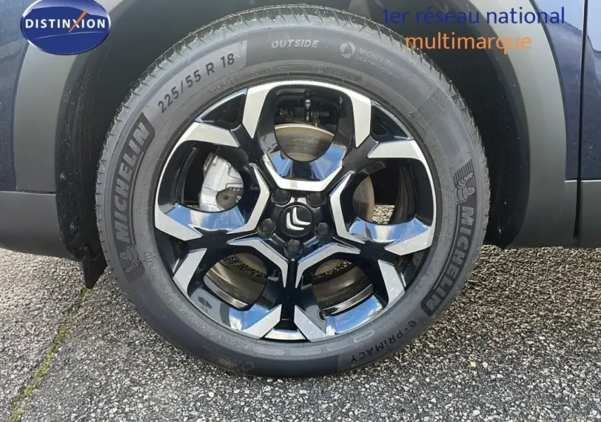 Gros plan sur la roue avant droite d'un Citroën C5 Aircross bleu Eclipse Métal avec jante alliage noire et argentée.