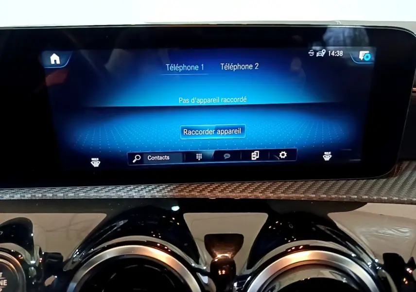 Vue rapprochée de l'écran tactile et des aérateurs ronds du tableau de bord de la Mercedes Classe A gris foncé.
