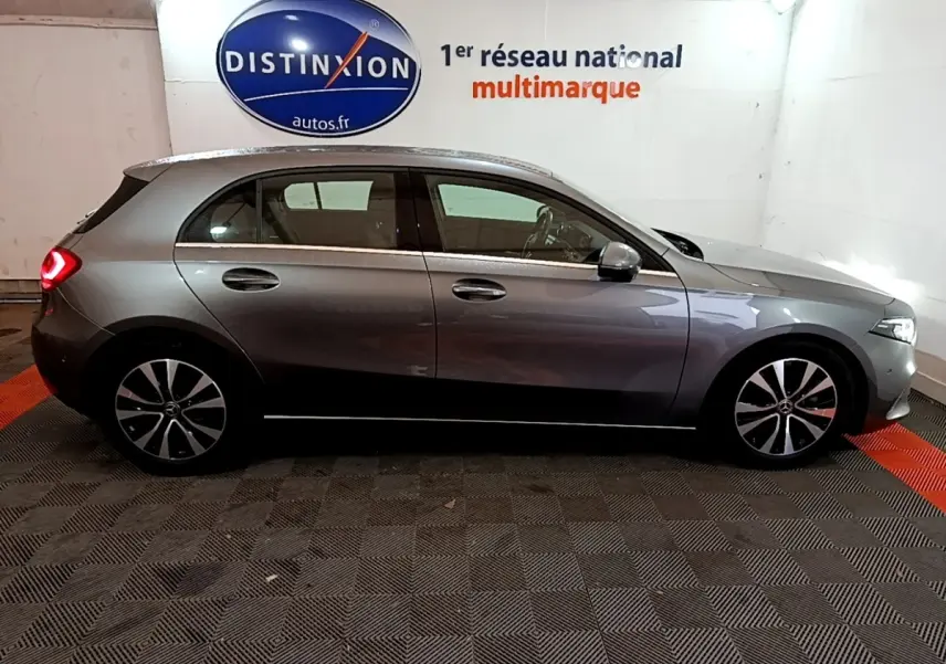 Vue de profil côté droit d'une Mercedes Classe A A 180 d Business Line gris foncé en intérieur showroom.