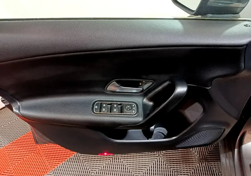 Vue rapprochée de la porte avant gauche noire avec commandes électriques des vitres et rétroviseur d'une Mercedes Classe A 180 d.