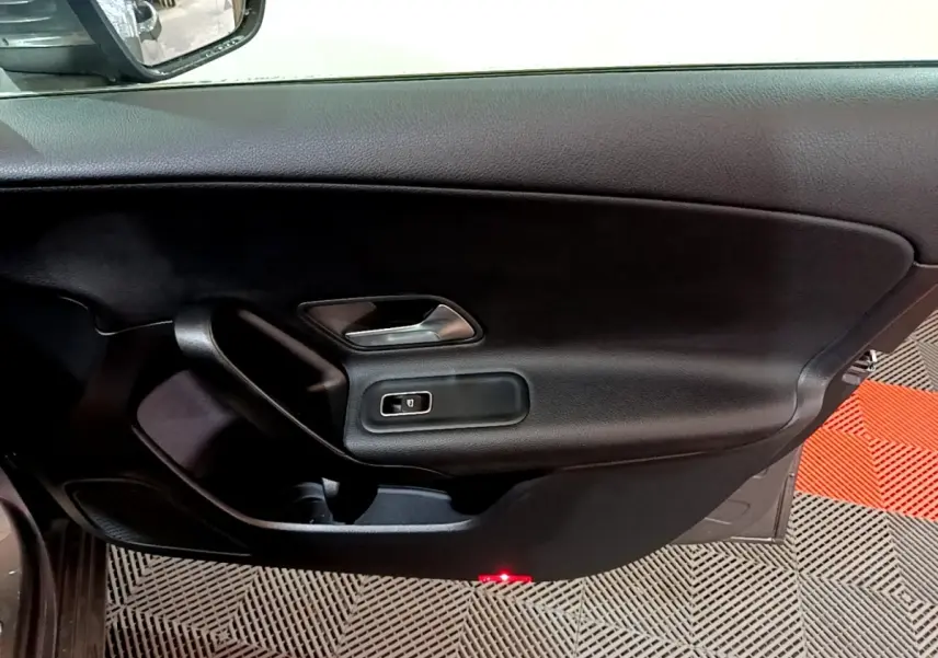 Vue intérieure côté gauche de la porte d’une Mercedes Classe A 180 d Business Line 2021 avec garniture noire et poignée argentée.