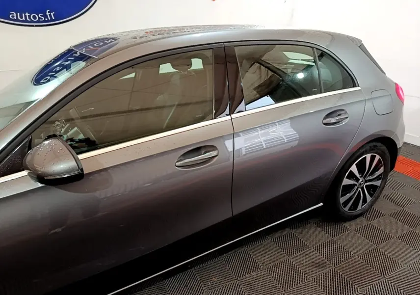 Vue côté gauche d'une Mercedes Classe A gris foncé, mettant en valeur les jantes alliage et les poignées de porte.