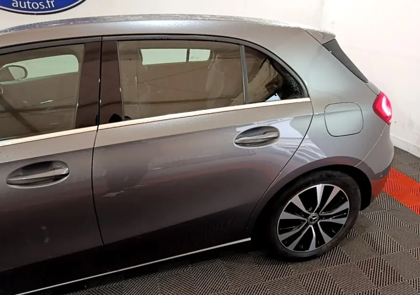 Vue latérale droite d'une Mercedes Classe A gris foncé, mettant en valeur les jantes alliage et les poignées de porte.