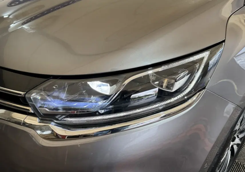 Gros plan sur le phare avant droit LED du Renault Espace gris foncé, soulignant les détails chromés autour.