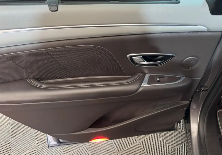 Vue côté gauche de la porte intérieure en cuir noir avec poignée alu et éclairage de seuil rouge du Renault Espace gris foncé 2015.