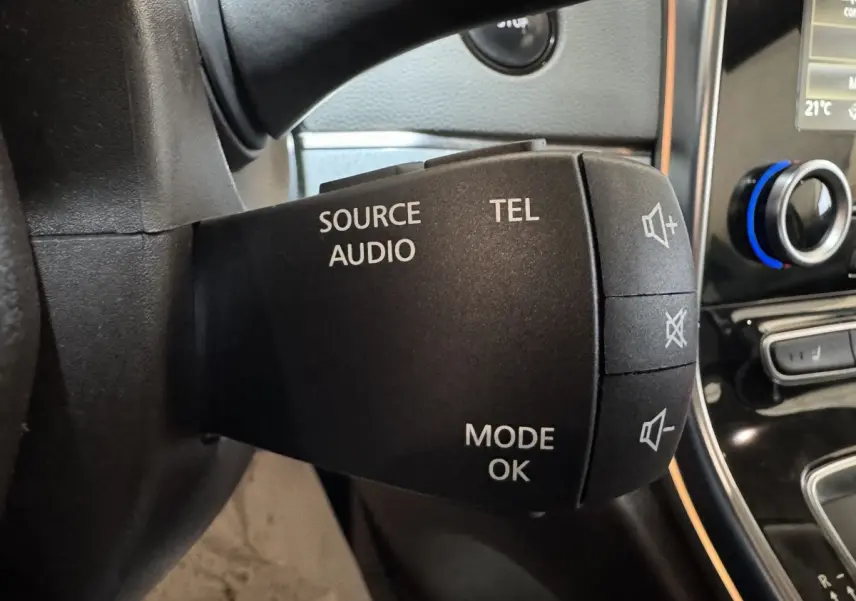 Gros plan sur la commande audio au volant d’un Renault Espace gris foncé, avec boutons source, téléphone et volume.