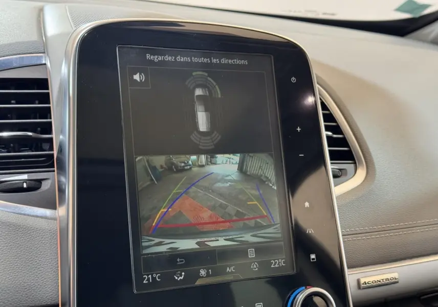 Écran tactile central montrant la caméra de recul et l’aide au stationnement du Renault Espace gris foncé, vue intérieure avant.
