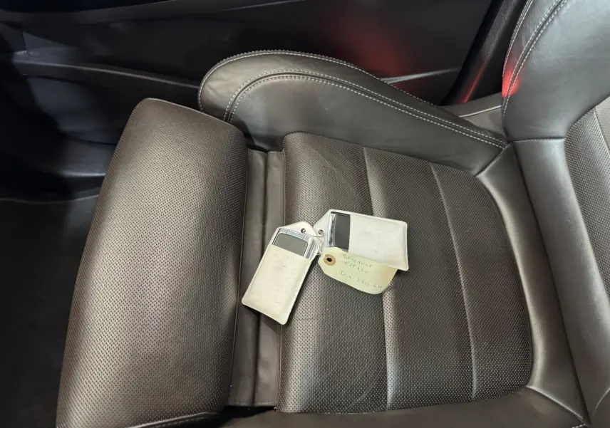 Gros plan sur le siège avant droit en cuir perforé gris foncé du Renault Espace 2015 avec clés posées dessus.