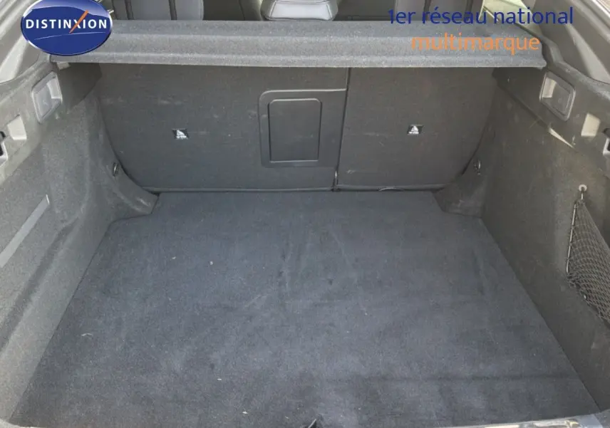 Coffre spacieux de Peugeot 408 gris selenium metal vu de l'intérieur avec banquette arrière en arrière-plan.