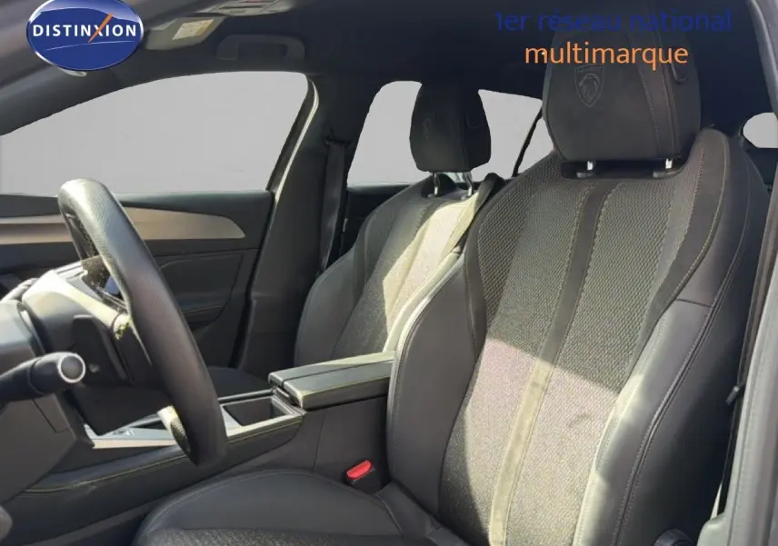 Vue intérieure côté gauche montrant les sièges avant en tissu et cuir noir avec logo Peugeot brodé sur les appuie-têtes.